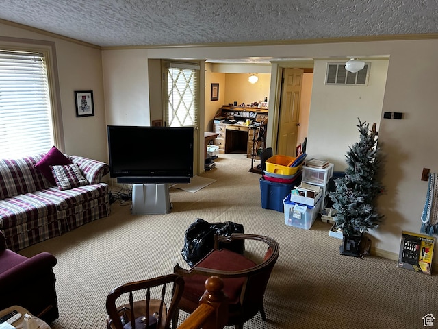 living room with ornamental molding, visible vents, carpet floors, and a textured ceiling