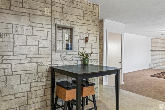 carpeted dining room featuring a textured ceiling and tile patterned floors