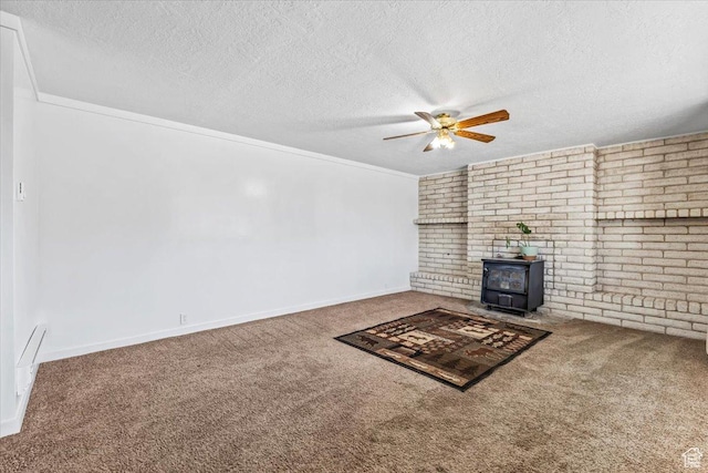 unfurnished living room with carpet flooring, a textured ceiling, a wood stove, and a ceiling fan