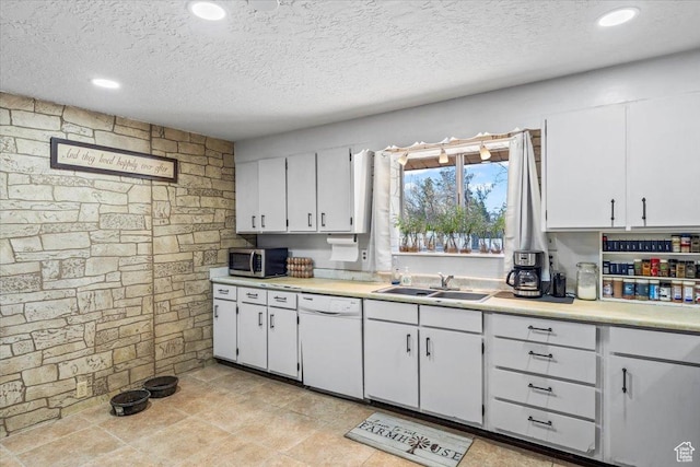 kitchen with dishwasher, stainless steel microwave, a sink, and light countertops