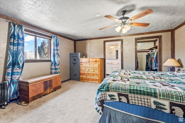 bedroom with crown molding, a textured wall, carpet, a textured ceiling, and a ceiling fan