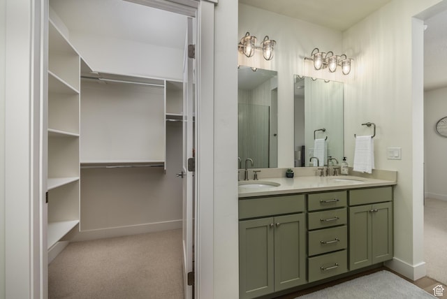 757 W Periwinkle Ln Unit 210, St George, UT 84790 - bathroom featuring double vanity, baseboards, a walk in closet, and a shower with door