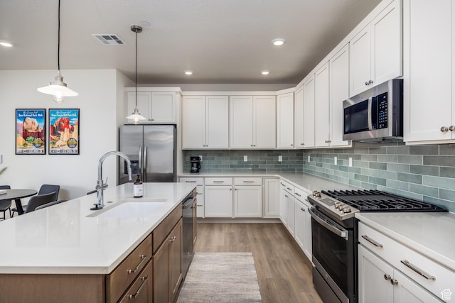 757 W Periwinkle Ln Unit 210, St George, UT 84790 - kitchen featuring stainless steel appliances, a sink, light wood-style flooring, light countertops, and white cabinetry