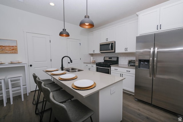 6219 W S Jordan Pkwy Unit 221, South Jordan, UT 84009 - kitchen featuring a breakfast bar area, a sink, stainless steel appliances, white cabinets, and tasteful backsplash
