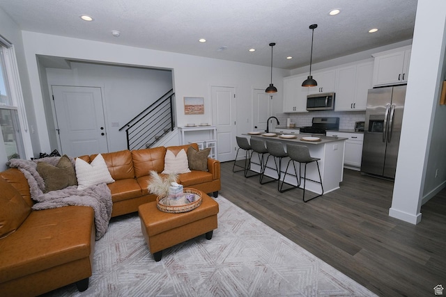 6219 W S Jordan Pkwy Unit 221, South Jordan, UT 84009 - living area featuring recessed lighting, stairs, baseboards, and dark wood-style flooring