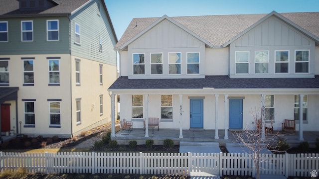 6219 W S Jordan Pkwy Unit 221, South Jordan, UT 84009 - view of front of home featuring a fenced front yard, covered porch, board and batten siding, and roof with shingles