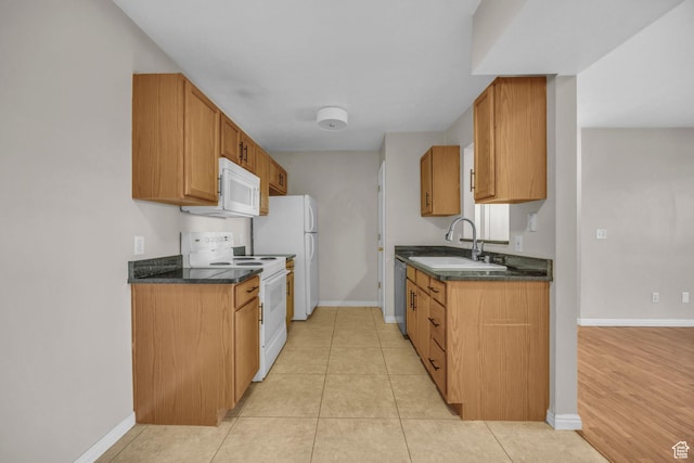 3860 S Mccall St Unit 2D, South Salt Lake, UT 84115 - kitchen featuring a sink, brown cabinetry, baseboards, light tile patterned floors, and white appliances
