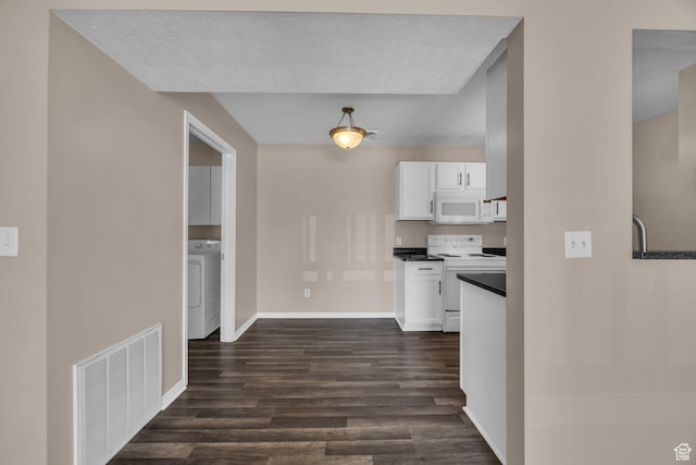 3860 S Mccall St Unit 2D, South Salt Lake, UT 84115 - kitchen featuring white appliances, washer / clothes dryer, dark wood-type flooring, and white cabinetry