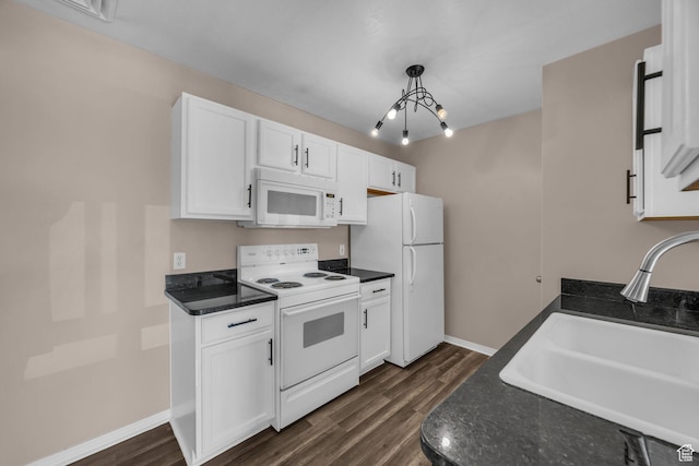3860 S Mccall St Unit 2D, South Salt Lake, UT 84115 - kitchen featuring white appliances, dark countertops, white cabinetry, dark wood-style floors, and pendant lighting
