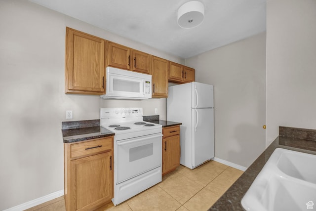 3860 S Mccall St Unit 2D, South Salt Lake, UT 84115 - kitchen featuring light tile patterned flooring, a sink, brown cabinetry, baseboards, and white appliances