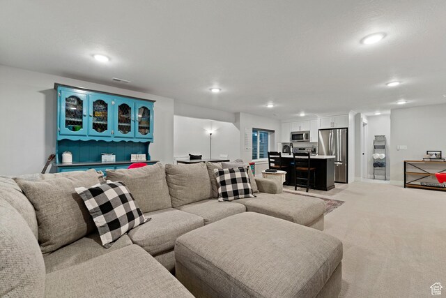 living room with recessed lighting, light carpet, baseboards, and visible vents