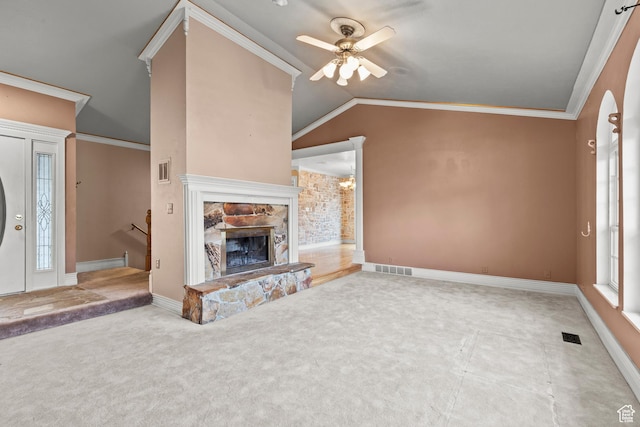 unfurnished living room featuring carpet flooring, ceiling fan, a stone fireplace, lofted ceiling, and visible vents