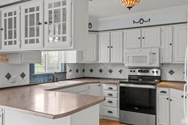 kitchen with crown molding, a sink, white microwave, a peninsula, and stainless steel electric stove