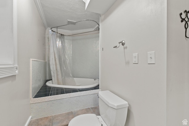 bathroom featuring tile patterned flooring, a textured ceiling, tiled shower / bath, and toilet