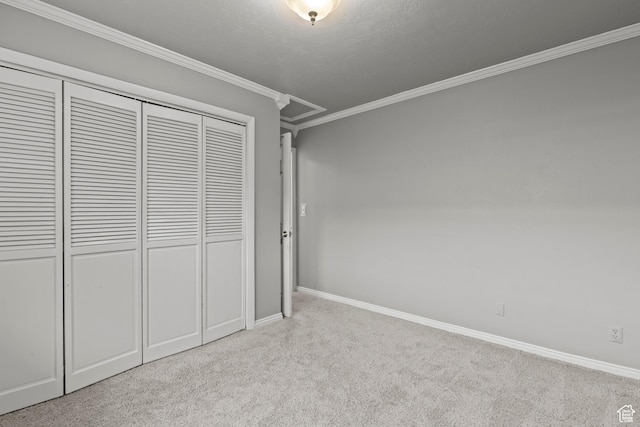 unfurnished bedroom featuring carpet floors, baseboards, ornamental molding, and a closet