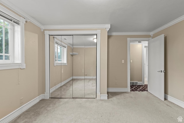 unfurnished bedroom with crown molding, carpet floors, and a closet