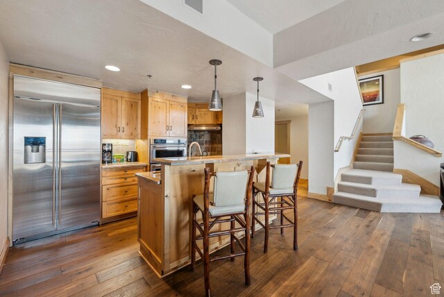 3855 Grand Summit Dr Unit 701Q3, Park City, UT 84098 - kitchen with light countertops, visible vents, a breakfast bar, dark wood finished floors, and appliances with stainless steel finishes
