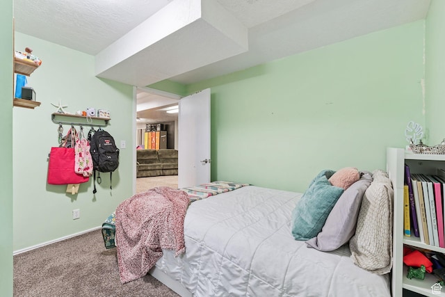 carpeted bedroom featuring baseboards and a textured ceiling