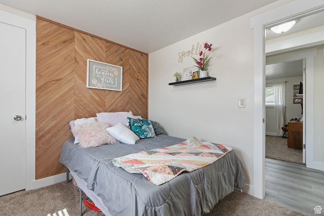 bedroom featuring baseboards and wooden walls