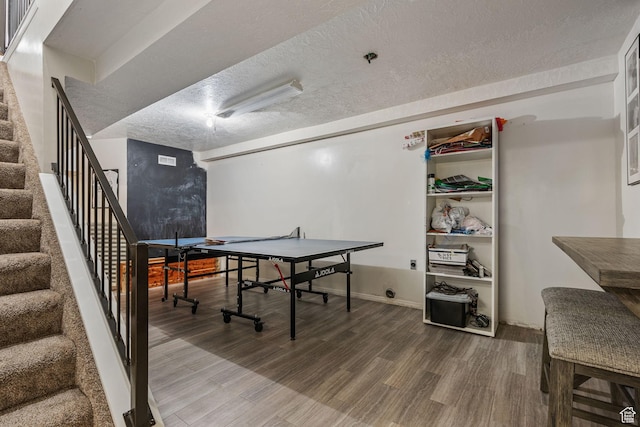 rec room with visible vents, a textured ceiling, and wood finished floors