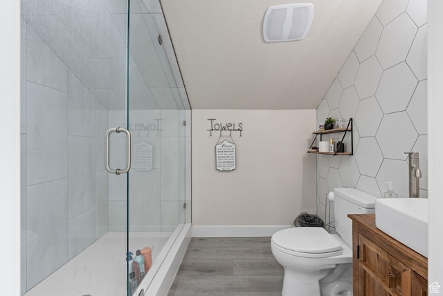 bathroom featuring visible vents, wood finished floors, toilet, a stall shower, and vaulted ceiling