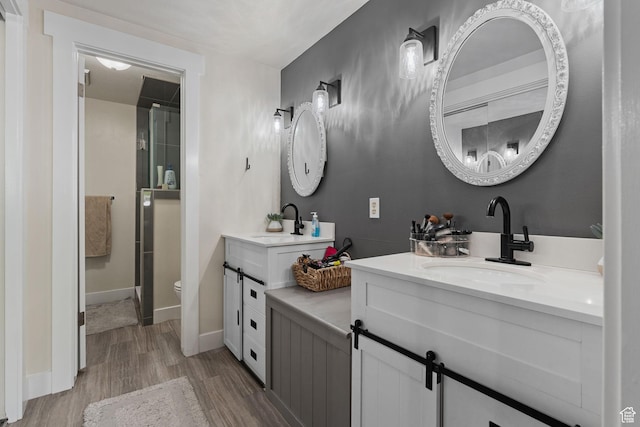 bathroom with a sink, a shower stall, and wood finished floors