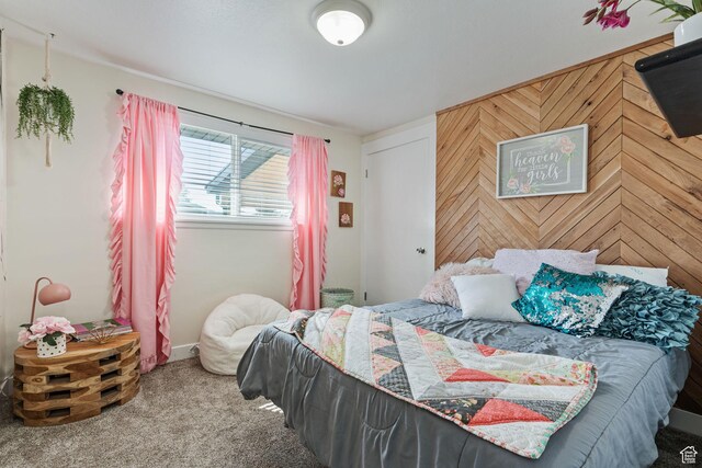 carpeted bedroom with wooden walls