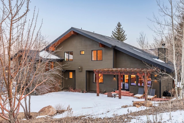 snow covered property with a chimney