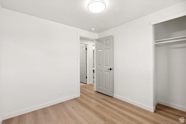 760 E 8080 S, Sandy, UT 84094 - unfurnished bedroom featuring baseboards, light wood-style flooring, a closet, and a textured ceiling