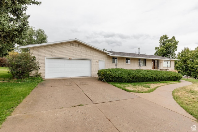 single story home featuring driveway, a front yard, an attached garage, and brick siding