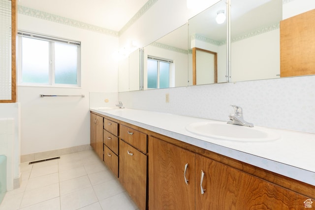 full bath featuring backsplash, a sink, tile patterned flooring, baseboards, and double vanity