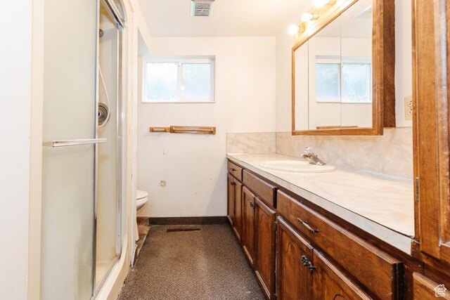 full bath with a stall shower, toilet, vanity, baseboards, and visible vents