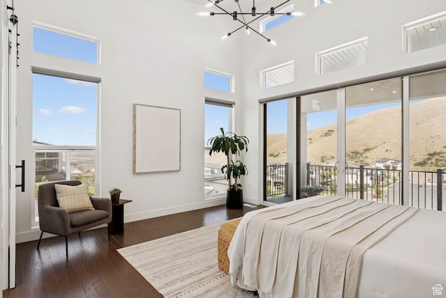 5641 N Canyon Rim Rd, Lehi, UT 84043 - bedroom featuring access to exterior, a chandelier, wood finished floors, baseboards, and a towering ceiling