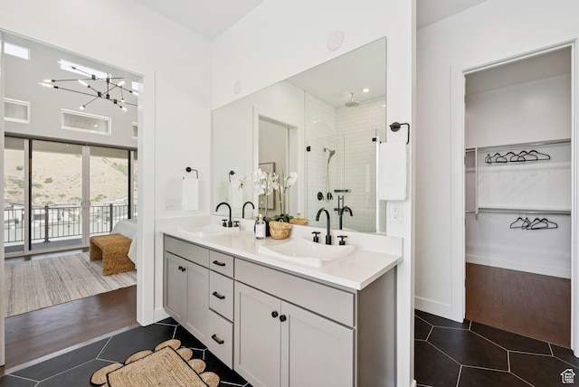 5641 N Canyon Rim Rd, Lehi, UT 84043 - bathroom featuring tile patterned flooring, double vanity, a stall shower, a chandelier, and a walk in closet