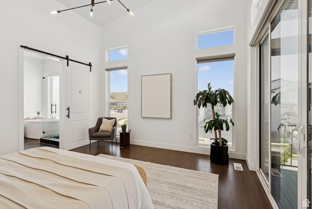 5641 N Canyon Rim Rd, Lehi, UT 84043 - bedroom with a barn door, a high ceiling, dark wood-type flooring, baseboards, and ensuite bathroom