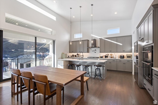 dining space with dark wood-style floors, a high ceiling, and recessed lighting