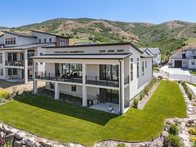 5641 N Canyon Rim Rd, Lehi, UT 84043 - rear view of property featuring a balcony, stucco siding, a mountain view, and a yard