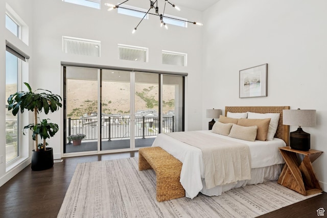 5641 N Canyon Rim Rd, Lehi, UT 84043 - bedroom featuring access to exterior, a towering ceiling, wood finished floors, a chandelier, and baseboards