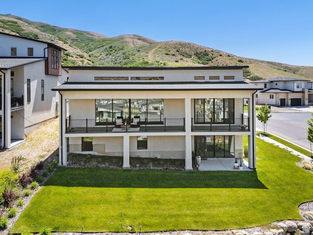 5641 N Canyon Rim Rd, Lehi, UT 84043 - rear view of house featuring a mountain view, stucco siding, a balcony, and a yard
