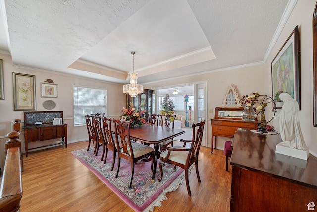 1376 Granada Dr, Bountiful, UT 84010 - dining area featuring a tray ceiling, crown molding, light wood-style floors, and a notable chandelier