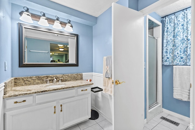 1376 Granada Dr, Bountiful, UT 84010 - bathroom featuring a shower with shower door, tile patterned flooring, vanity, and a wainscoted wall