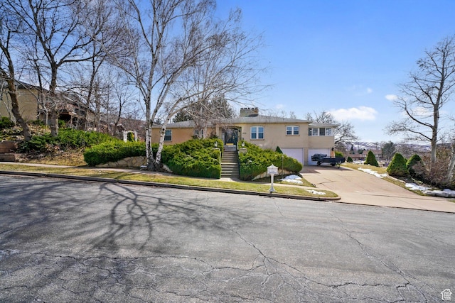 1376 Granada Dr, Bountiful, UT 84010 - view of front of home featuring a garage, driveway, stucco siding, and stairs