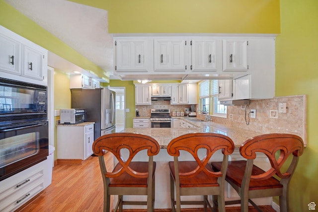 1376 Granada Dr, Bountiful, UT 84010 - kitchen with black appliances, under cabinet range hood, white cabinets, and a peninsula