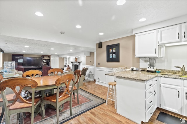 1376 Granada Dr, Bountiful, UT 84010 - dining room featuring light wood-style flooring, wainscoting, recessed lighting, and bar