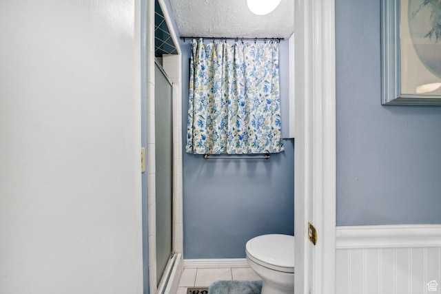 1376 Granada Dr, Bountiful, UT 84010 - full bath featuring a textured ceiling, toilet, a shower with door, tile patterned flooring, and wainscoting