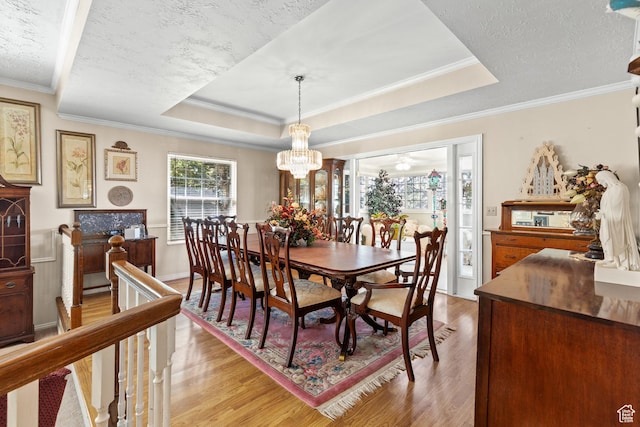 1376 Granada Dr, Bountiful, UT 84010 - dining area with light wood-style flooring, a chandelier, crown molding, a raised ceiling, and a textured ceiling