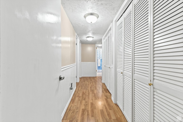 1376 Granada Dr, Bountiful, UT 84010 - corridor with a textured ceiling, light wood finished floors, and a wainscoted wall