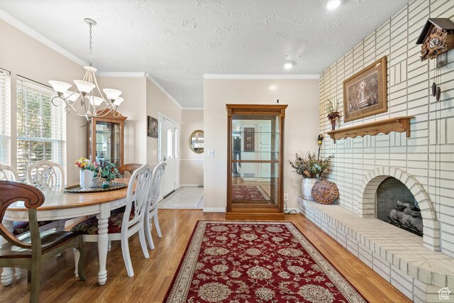 1376 Granada Dr, Bountiful, UT 84010 - dining space with a chandelier, light wood finished floors, a textured ceiling, ornamental molding, and a fireplace