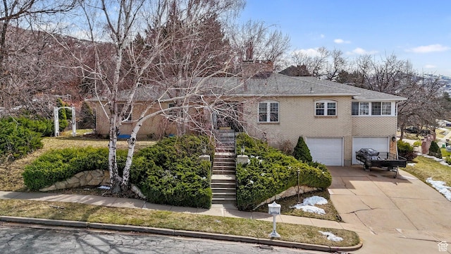 1376 Granada Dr, Bountiful, UT 84010 - view of front of home featuring stairs, driveway, an attached garage, and brick siding