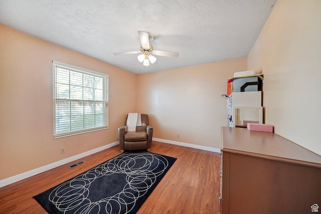 1376 Granada Dr, Bountiful, UT 84010 - sitting room with baseboards, a textured ceiling, ceiling fan, and light wood-type flooring